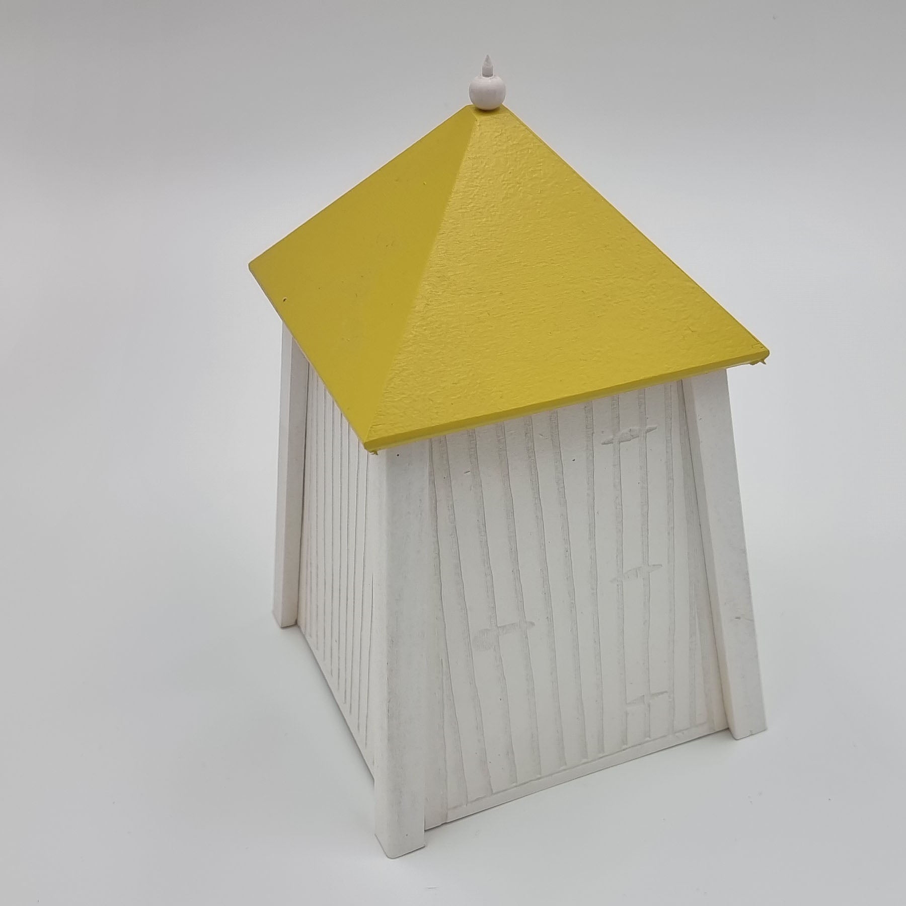 A handcrafted wooden miniature of a traditional beach cabin from Hanko, Finland, featuring a red roof and white painted walls