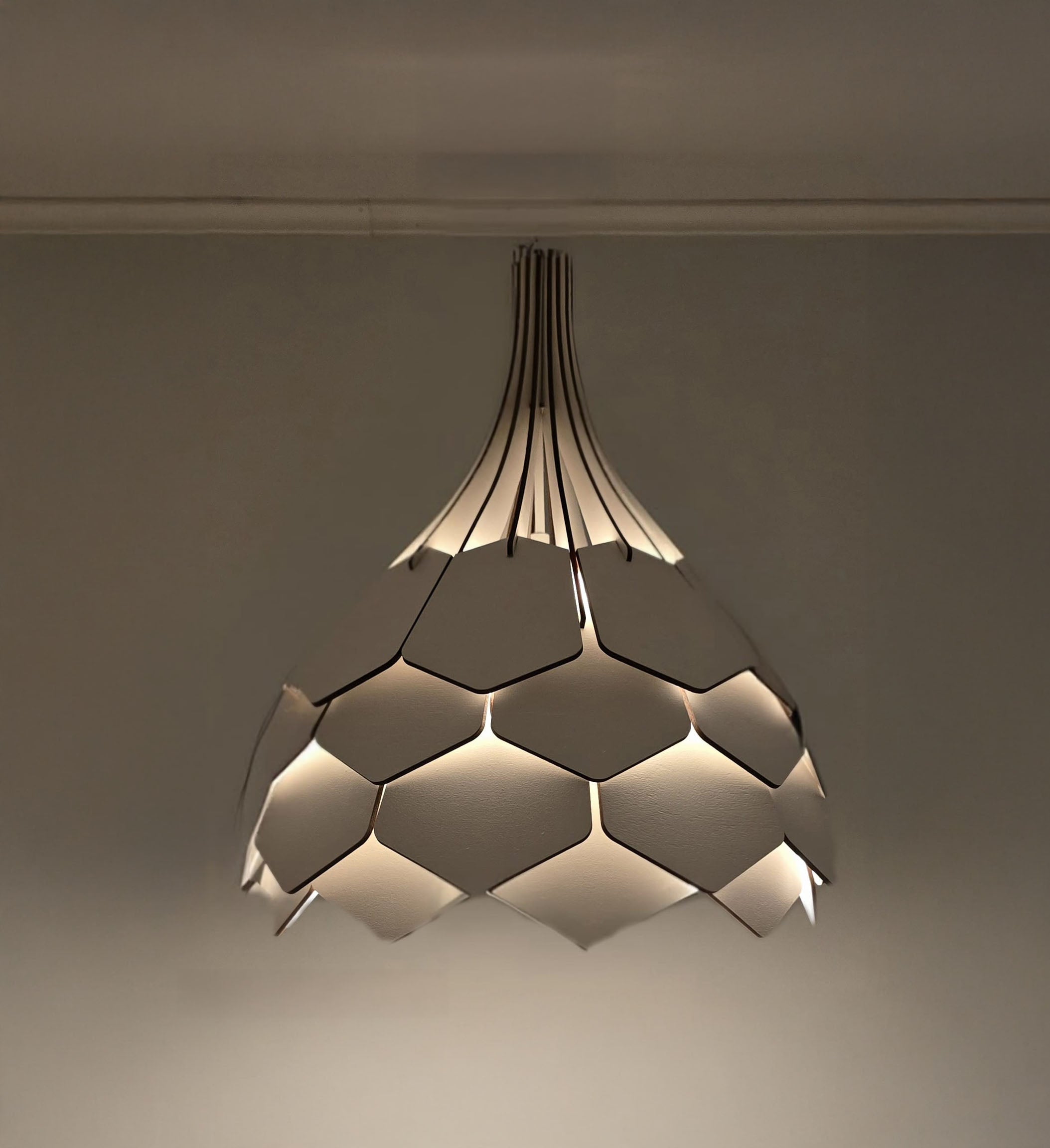 A ceiling-mounted pendant lamp with a geometric, nature-inspired design in a warm color, hanging from a straight rod.