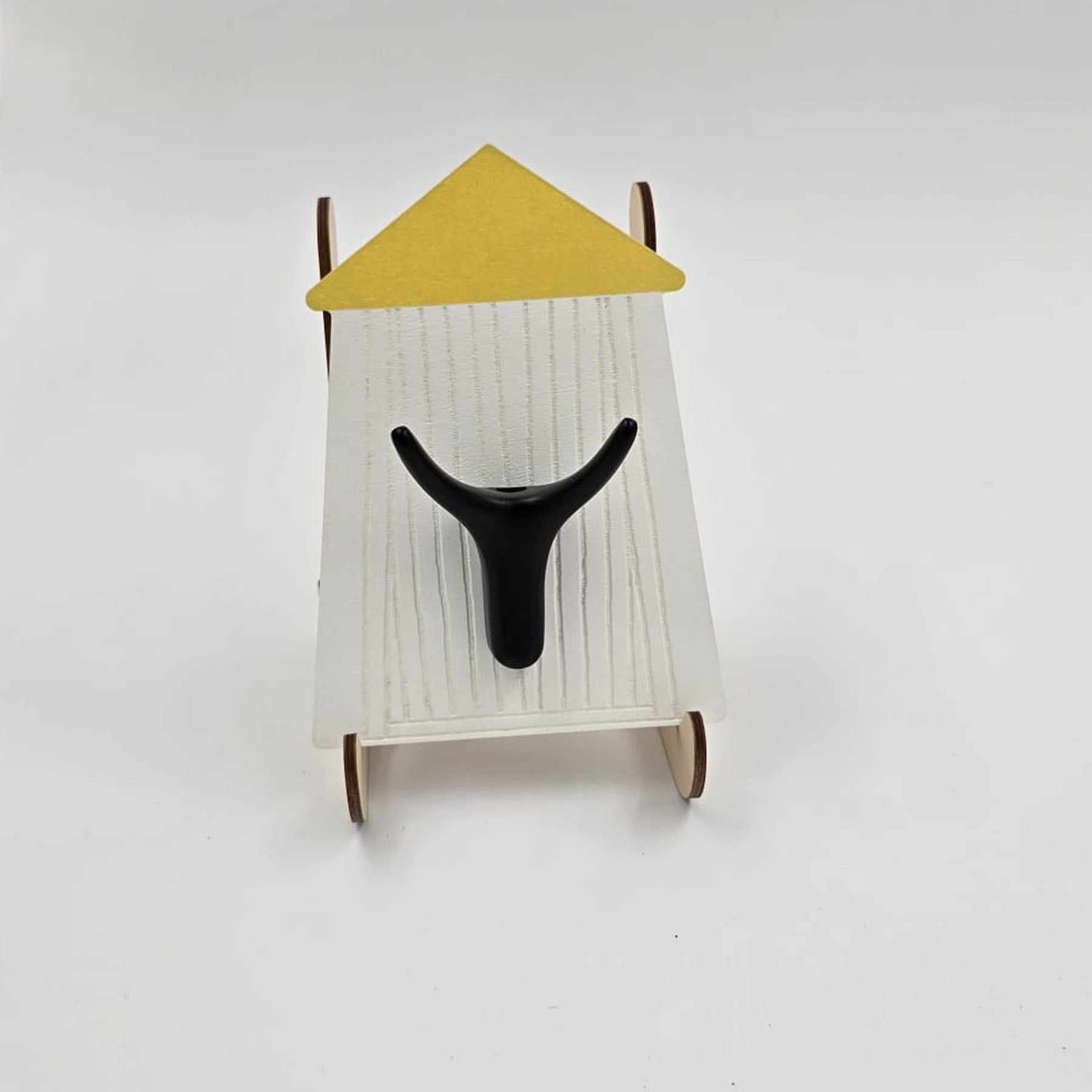 A wall hook with a white background designed to resemble a coastal bathroom scene, with a dark brown hook and a yellow roof.