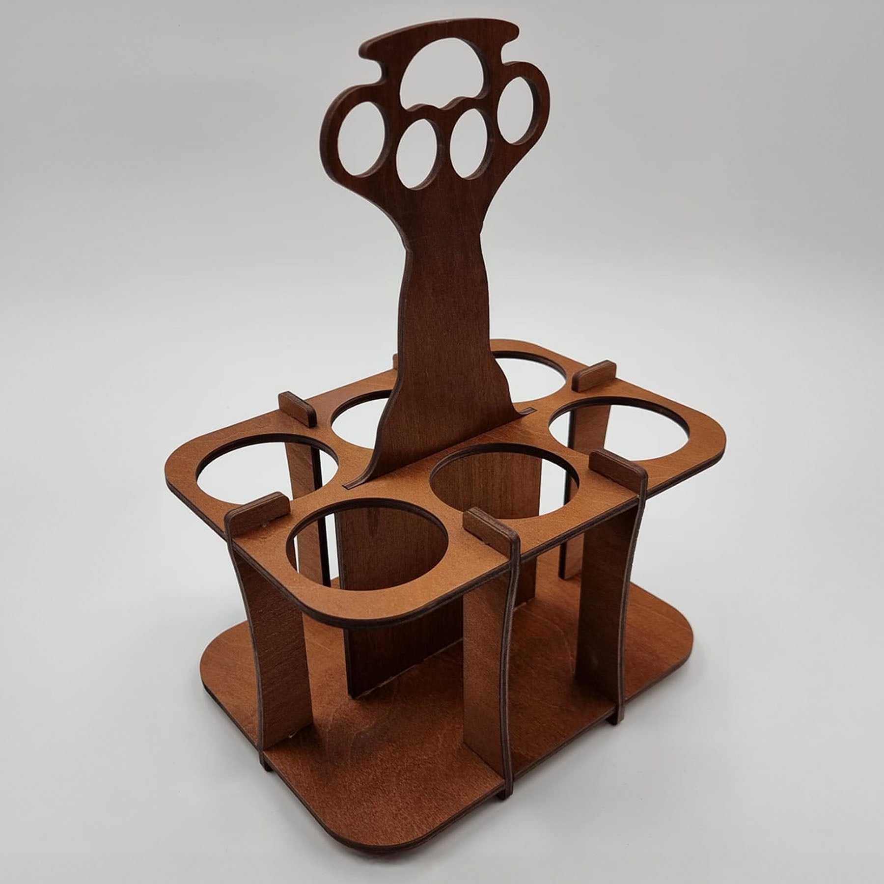 A wooden six-pack carrier with a handle shaped like brass knuckles, designed to hold multiple bottles or cans.