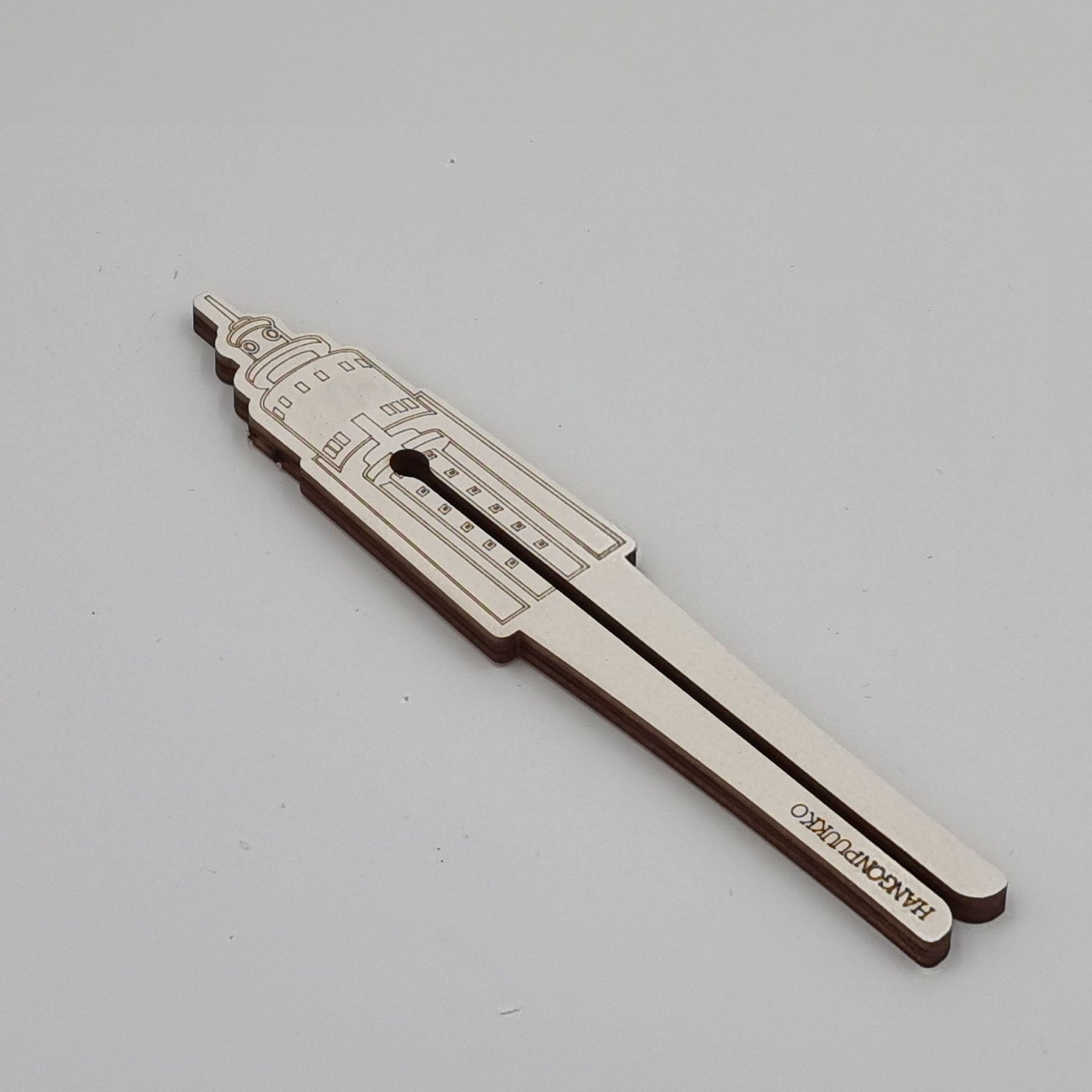 A silver-colored metal tube squeezer with a sleek design, featuring a slot to squeeze tubes.